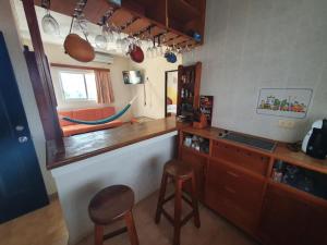 a kitchen with a counter and two stools in it at Suites Los Arcos in Isla Mujeres