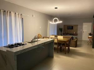 a kitchen and living room with a table and a dining room at Casa aconchegante 303 sul in Palmas