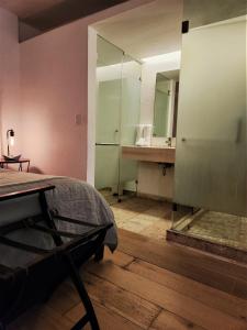 een slaapkamer met een bed en een badkamer met een spiegel bij Downtown Ciudad de México in Mexico-Stad