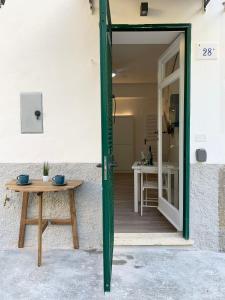 eine Tür, die auf eine Terrasse mit einem Tisch führt in der Unterkunft Casetta Lorica Porto Santo Stefano in Porto Santo Stefano