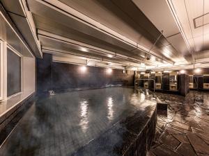 a swimming pool in a large room with a pool at APA Hotel Kyoto Eki Horikawadori in Kyoto