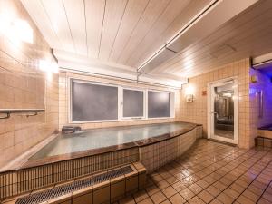 a bathroom with a large tub in a room at APA Hotel Kyoto Eki Horikawadori in Kyoto