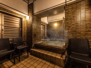 a hot tub in a room with two chairs at APA Hotel Kyoto Eki Horikawadori in Kyoto