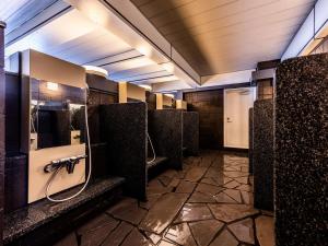 a bathroom with a row of stalls in a public restroom at APA Hotel Kyoto Eki Horikawadori in Kyoto
