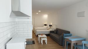 a living room with a couch and a bed at Apartamentos y estudios EL CENTRO in Vargas
