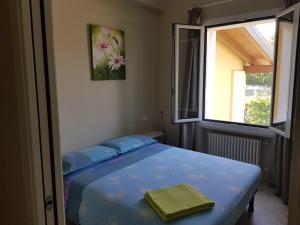 a bedroom with a blue bed with a window at Graziosa Al Porto in Moniga