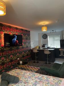 a living room with a flat screen tv on a wall at Luxury studio apartment near Birmingham citycentre in Birmingham