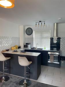 a kitchen with a counter and two bar stools at Luxury studio apartment near Birmingham citycentre in Birmingham