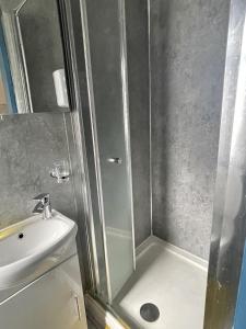 a shower with a glass door next to a sink at Luxury studio apartment near Birmingham citycentre in Birmingham