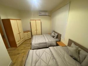 ein kleines Schlafzimmer mit 2 Betten und einer Kommode in der Unterkunft فيلا درة العروس الشاطئ الذهبي in Durrat Al-Arus