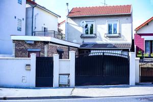 a black gate in front of a house at chez Moon in Le Blanc-Mesnil