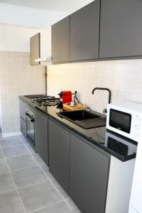 a kitchen with a sink and a microwave at chez Moon in Le Blanc-Mesnil