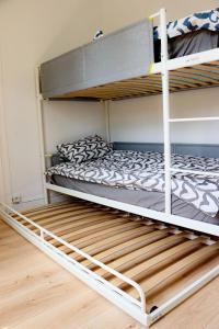 two bunk beds in a room with a wooden floor at chez Moon in Le Blanc-Mesnil
