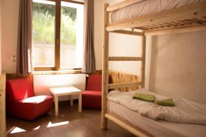 a bedroom with a bunk bed and a chair and a window at Ловен Дом Мечи Кът in Chepelare