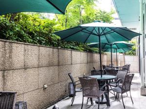 a patio with tables and chairs with umbrellas at APA Hotel Kyoto Eki Horikawadori in Kyoto