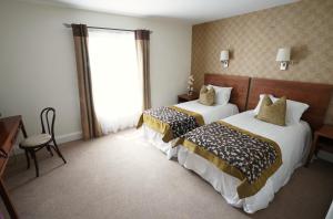 um quarto de hotel com duas camas e uma janela em The Castledawson Inn em Magherafelt