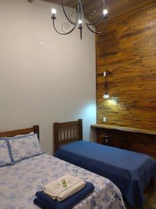 1 Schlafzimmer mit 2 Betten und einem Kronleuchter in der Unterkunft Hospedagem Caminho do Lago in Cunha
