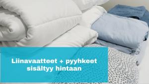 a pile of pillows sitting on top of a bed at Northern Lights - Cozy apartment, sisältää liinavaatteet in Kalajoki