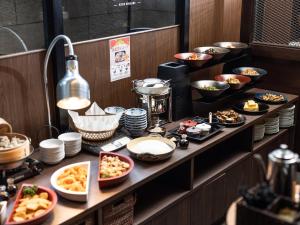 a buffet line with dishes of food on a table at APA Hotel Kyoto Eki Horikawadori in Kyoto