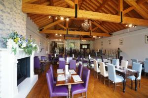 a dining room with tables and purple chairs at The Castledawson Inn in Magherafelt