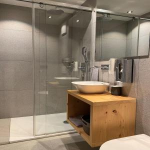 uma casa de banho com um lavatório e uma cabina de duche em vidro. em Adults Only Hotel Mulin - Das Erwachsenen-Hotel in den Bergen em Brigels
