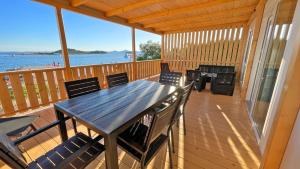 a wooden deck with a table and chairs on it at Cottage JANICE Beach in Pakoštane
