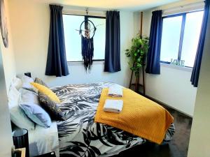 ワナカにあるHawea Heaven: Superking beds + Hot Tub + Mountainの窓のある部屋にベッドがある寝室