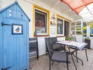 a blue shed with a table and chairs on a patio at Snug Bungalow in Insel Poel Germany near Beach in Fährdorf