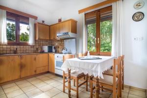 uma cozinha com mesa e cadeiras e uma cozinha com fogão em Plakias Villas em Lefkogeia