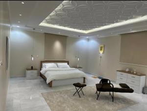 1 dormitorio grande con 1 cama, mesa y sillas en ذكريات الصيف en Taif