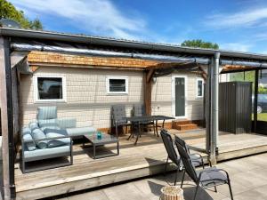 a deck with a pergola and a table and chairs at Camping Kleine Belterwijde, Haven Chalet in Belt-Schutsloot