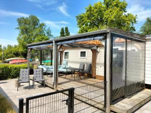 a gazebo with a table and chairs on a patio at Camping Kleine Belterwijde, Haven Chalet in Belt-Schutsloot