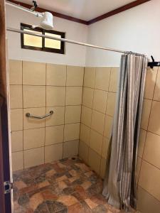 ein Bad mit Dusche und Duschvorhang in der Unterkunft RIVER SIDE LODGE in Horquetas