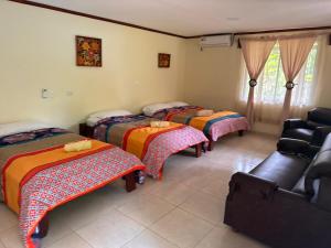 eine Gruppe von 4 Betten in einem Zimmer in der Unterkunft RIVER SIDE LODGE in Horquetas