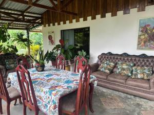 ein Wohnzimmer mit einem Tisch und einem Sofa in der Unterkunft RIVER SIDE LODGE in Horquetas