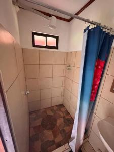 a bathroom with a shower with blue and red curtains at RIVER SIDE LODGE in Horquetas