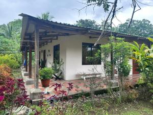 una pequeña casa en medio de un jardín en RIVER SIDE LODGE, en Horquetas