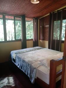 ein Schlafzimmer mit einem Bett in einem Zimmer mit Fenstern in der Unterkunft Hotel Anachoreo in Santa Fé