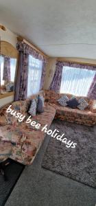 a living room with a couch and two windows at The Hive on The Chase Ingoldmells in Skegness