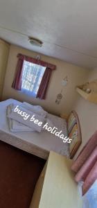 a small room with a bed with the words just be kidding at The Hive on The Chase Ingoldmells in Skegness