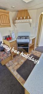 a kitchen with a stove and a counter top at The Hive on The Chase Ingoldmells in Skegness