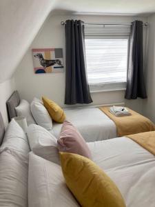 een slaapkamer met 2 bedden en een raam bij Park View House in Maghull