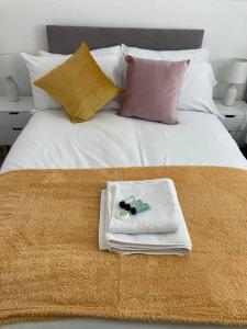 a white bed with towels and pillows on it at Park View House in Maghull