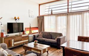 uma sala de estar com um sofá e uma televisão em Bungalowpark Wijdland - Aak em Bunschoten