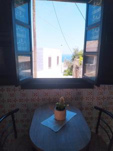a table with a potted plant sitting on top of a window at Patmos house Leo & Mary in Patmos