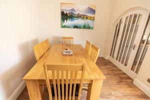 Stunning Holiday Home - Puddleduck - Centre of Coniston في كونيستون: غرفة طعام مع طاولة وكراسي خشبية