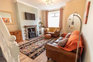 sala de estar con sofá y chimenea en Stunning Holiday Home - Puddleduck - Centre of Coniston en Coniston