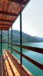 a wooden bench sitting on the side of a lake at Lakeside Luxury Apartments in Jablanica