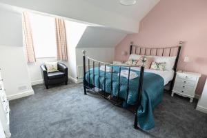 um quarto com uma cama e uma cadeira em Stunning Holiday Home - Puddleduck - Centre of Coniston em Coniston