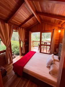 ein Schlafzimmer mit einem großen Bett in einem Zimmer mit Fenstern in der Unterkunft Cattaleya in Yumbo